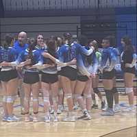 <p>Coach William Scully with his volleyball team</p>