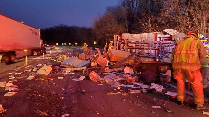 A driver was rescued and taken to a nearby hospital after a U-Haul overturned and scattered debris across Route 80 Thursday morning, authorities said.