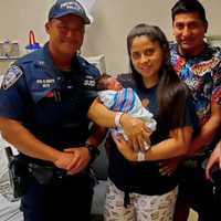 <p>Baby Kylian with his parents and the PAPD officers, Evan Butt and Timothy Jozefczyk, who delivered him just outside of the Lincoln Tunnel last July.</p>