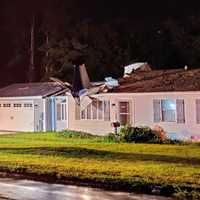 <p>In this photo, you can make out the part of the small aircraft planted in the roof of a Ring Drive home.</p>