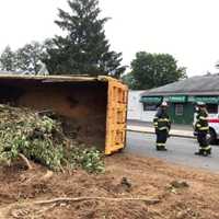 <p>An overturned dump truck has spread landscaper’s debris all over a city Avenue just in time for the Wed., Sept. 9 commute.</p>