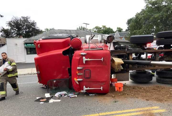 An overturned dump truck has spread landscaper’s debris all over a city Avenue just in time for the Wed., Sept. 9 commute.