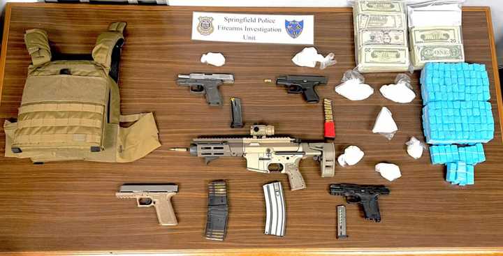 Springfield police show off the guns, cash, and drugs they seized during three raids on Tuesday, April 18.