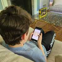 <p>A Southern Westchester BOCES middle school student reads from a phone.</p>