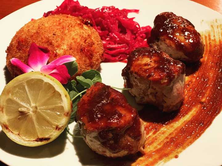 Byrd &amp; Baldwin Bros. Steakhouse is more than just steak. These pan-seared pork medallions with apple and molasses pan sauce served with pickled cabbage and peppadew pepper and gouda risotto cake look divine.