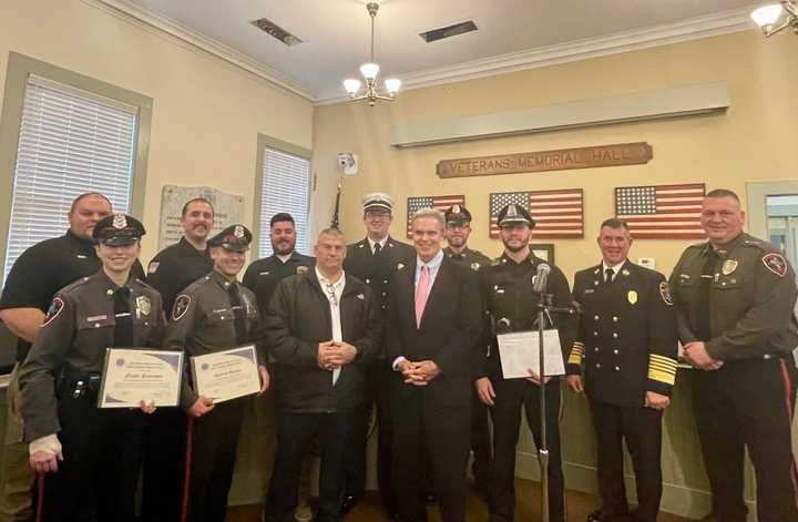 (Center front) District Attorney Joseph D. Early, right, and Officer Jeffrey Lavallee pose with the Sturbridge first responders who received the TEAM award on Wednesday, Feb. 28.&nbsp;