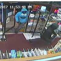 <p>Two suspects enter the Rainbow News and Variety in Norwalk Saturday night.</p>