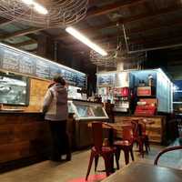 <p>TFS Burger Works&#x27; industrial decor plays up its past as a gas/service station. Its juicy burgers, however, are all-natural and made with beef from contented, grass-munching cattle.</p>