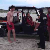 <p>Lyudmila Emag is helped by emergency crews following a shark attack near Fire Island on Tuesday, July 4.</p>