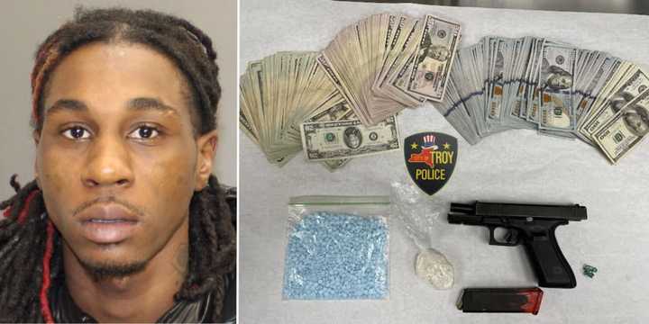 Richawn McClain, age 25, pictured with the gun, drugs, and cash he was allegedly busted with.&nbsp;