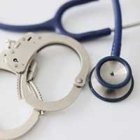 <p>Stethoscope and handcuffs</p>