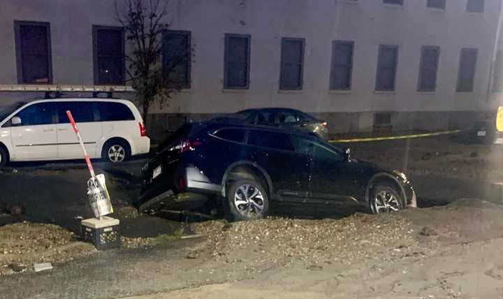 A water main bursts early Monday morning, Aug. 15, near Tremont Street in South End and caused a sinkhole that swallowed a 2022 Subaru.