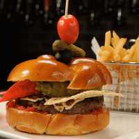 <p>Westchester Burger Company spears all its burgers with a garnish of pickled cucumber, olive, and cherry tomato garnish.</p>