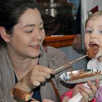 <p>A young visitor takes a big bite of chocolate at the expo on Sunday at the Maritime Aquarium at Norwalk.</p>