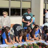 <p>Signing autographs</p>