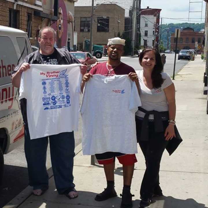 Paula Miritello, the founder of My Brother Vinny, stands with two vets who have been helped by the organization.