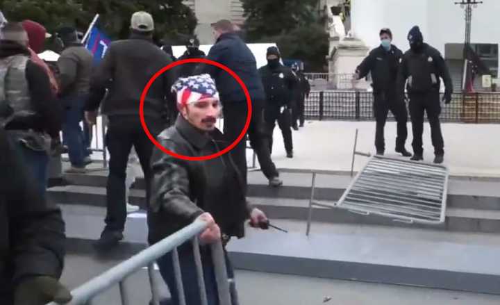 White Plains resident William Pepe is caught moving a barrier at the US Capitol in a photo released by the US Justice Department.