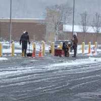 <p>Two guys with a snowblower and a shovel clear out a slushy area near the gas pumps at BJs Wholesale Club in Brookfield on Friday.</p>