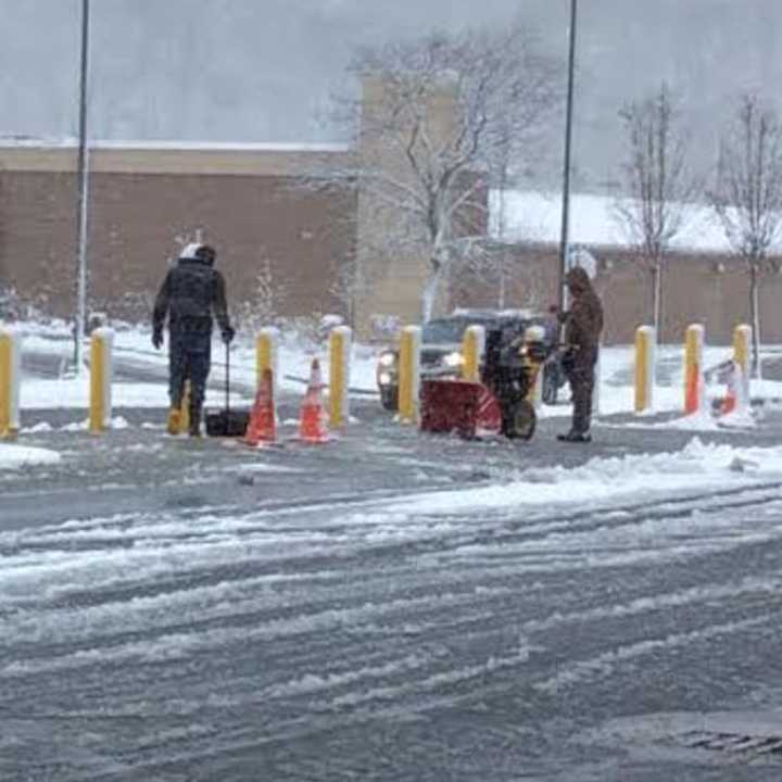 Two guys with a snowblower and a shovel clear out a slushy area near the gas pumps at BJs Wholesale Club in Brookfield on Friday.