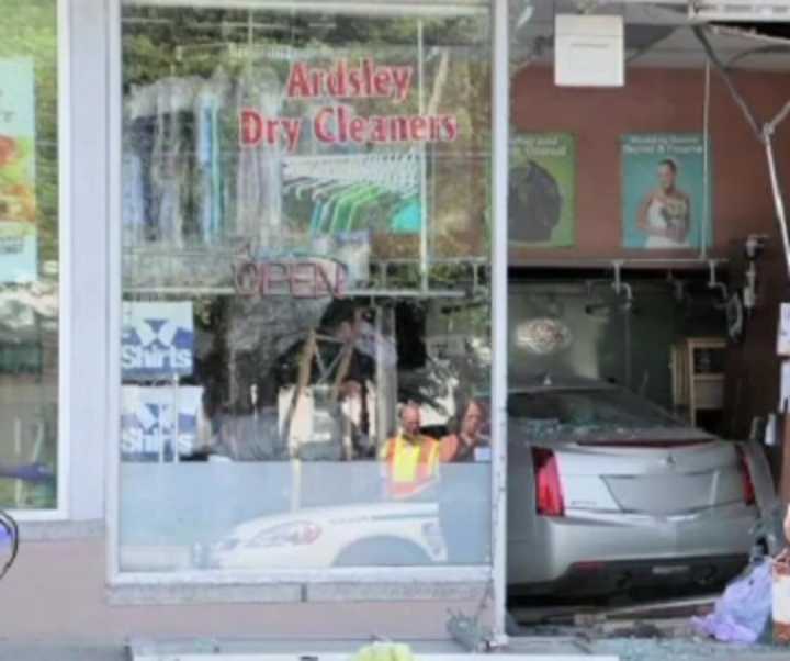 Clothes and debris lie scattered at the Ardsley Dry Cleaners Sunday after a woman drove her Cadillac through its front window. The store was closed at the time, but the bagel shop next door was packed with people having breakfast.