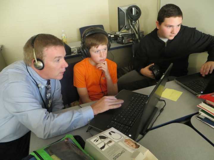 Teacher Dan Gaffney helps students at Henry Wells Middle School create their own music.