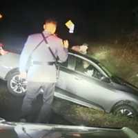 <p>Two NJ State Police troopers approach the crashed sedan just off Route 80 in Knowlton, NJ, on Nov. 7, 2021.</p>