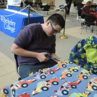 <p>Joshua Henry of Dumont works on a blanket for Project Linus, one of several projects Berkeley College students are involved in to commemorate Martin Luther King Jr. Day.</p>