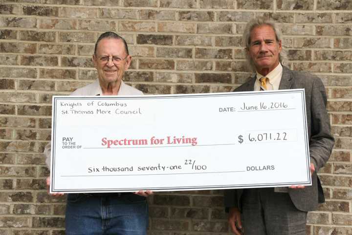 Mike Carpenter, Knights of Columbus St. Thomas More Council #2188 member and Spectrum for Living parent (left) presents a check for $6,071 to Mark Michelson, president and CEO of Spectrum for Living.