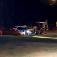 <p>The backhoe slams a police SUV and private sedan.</p>