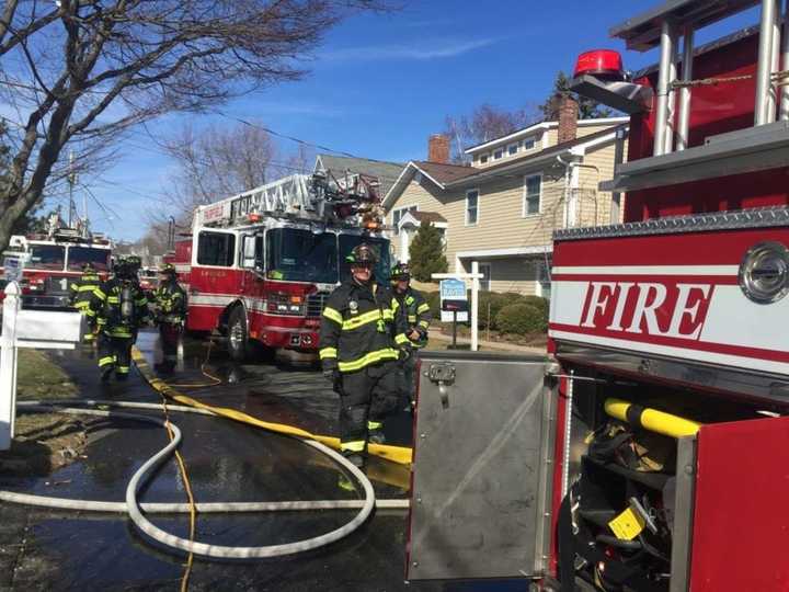 Firefighters spread hose at the scene at 318 Pine Creek Ave. in Fairfield on Thursday morning.