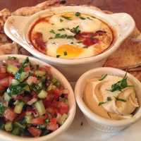 <p>Shakshouka, an egg-based dish, comes with whole wheat pita bread, freshly chopped salad and hummus on the side, at Farmhouse Café &amp; Eatery&#x27;s brunch.</p>