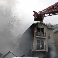 <p>Smoke and water streams rise in chasm left by collapsed building.</p>