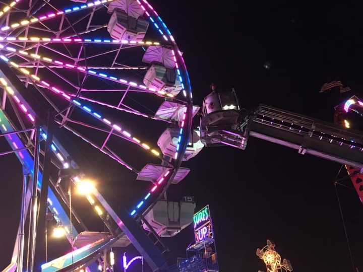 Stratford firefighters rescue two riders from the Ferris wheel after it stalled Wednesday night at the Rotary Club Carnival.