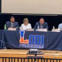 <p>Lodi Schools Supt. Douglas Petty (left) checks his phone during special Board of Education meeting Wednesday night, Aug. 31.</p>