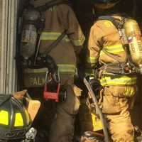 <p>Firefighters check the inside of the tractor-trailer.</p>