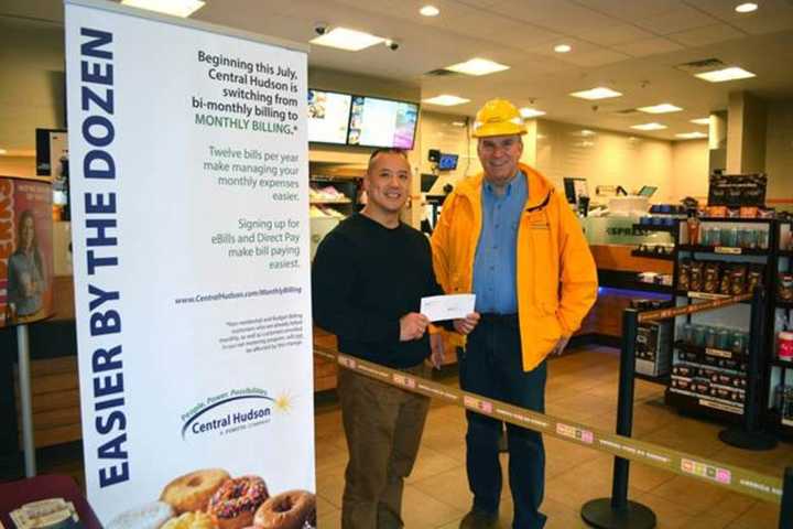 Central Hudson Gas &amp; Electric Operations Director Jeff Ferrara, right, handed out dozens of doughnuts at the Dunkin’ Donuts on Route 9. The franchise owner, Yuwen Chen, donated the proceeds to the Food Bank of the Hudson Valley.