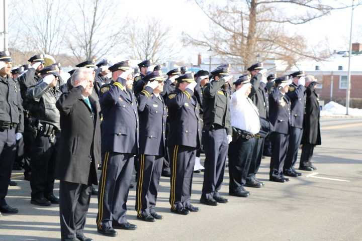 Members of the Norwalk Police Department, joined by former chief and current Mayor Harry Rilling, salute retired Lt. Tim Murphy after his Mass of Christian Burial on Saturday at St. Aloysius Church in New Canaan.