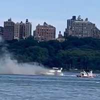 <p>Black smoke turns gray as fire boats on the Hudson River begin spraying the yacht.</p>