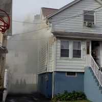 <p>Smoke was showing from the porch roof as the fire moved through the ceiling, Capt. Justin Derevyanik said.</p>