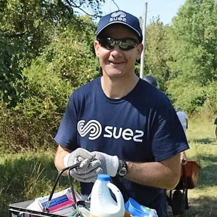 A volunteer carrying a basket of debris collected in the Oradell Reservoir watershed.