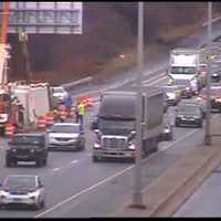 <p>A wrecker and work crew attempt to right a rolled over tractor-trailer on the shoulder of I-84 in Danbury on Wednesday. It was not clear how long it would take to clear the accident scene.</p>