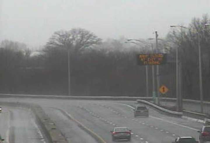 A sign on I-95 in Stratford warns of a closed exit ramp as heavy rain falls across the area.