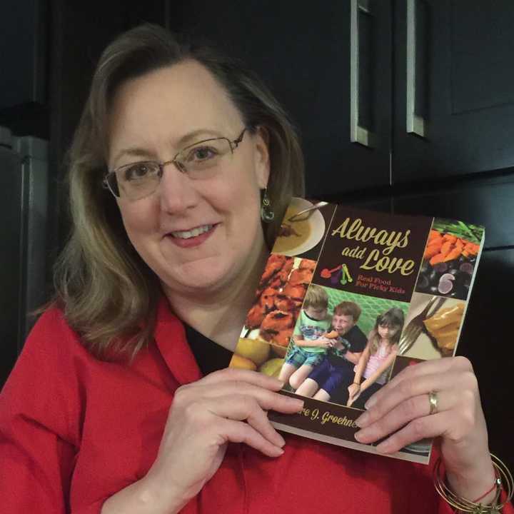 Ridgewood mom and food blogger Deidre Groehnert holds up a copy of her new book, Always Add Love. 