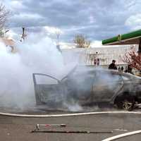 <p>Firefighters extinguish the Route 4 sedan blaze.</p>