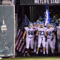 <p>Wayne Valley High School Co-Captain Jake Pluta carries the historic American flag onto the field.</p>