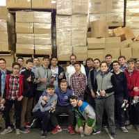 <p>Founders Sara Truzman-Fuerst, far left, and Ava Avidar-Hamburger, far right, stand with young volunteers in the warehouse where the packages are prepared for Jewish troops here in the U.S. and overseas.</p>