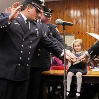 <p>Leonia Fire Chief Dan Neu&#x27;s daughter holds Bible during Monday night&#x27;s swearing in.</p>