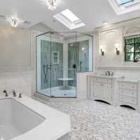 <p>The home&#x27;s ensuite bathroom, located off a spacious primary suite, features a spa tub, marble floors, and sky lights.</p>