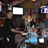 <p>Bartender and owner of The Cottage Bar, Mickey Dawson, pours a tall glass of beer for a customer in 2015.</p>