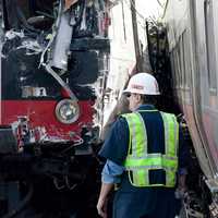 <p>National Transportation Safety Board workers inspect the damage at the site of the collision between two Metro North trains on the Bridgeport-Fairfield border.</p>